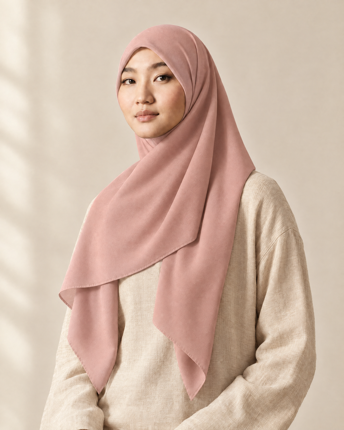 Hijab bawal segi empat Nuréa warna Merah Muda Lembut (Dusty Rose) dipakai model, tampak depan setengah badan