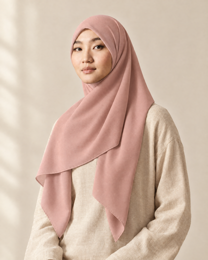 Hijab bawal segi empat Nuréa warna Merah Muda Lembut (Dusty Rose) dipakai model, tampak depan setengah badan