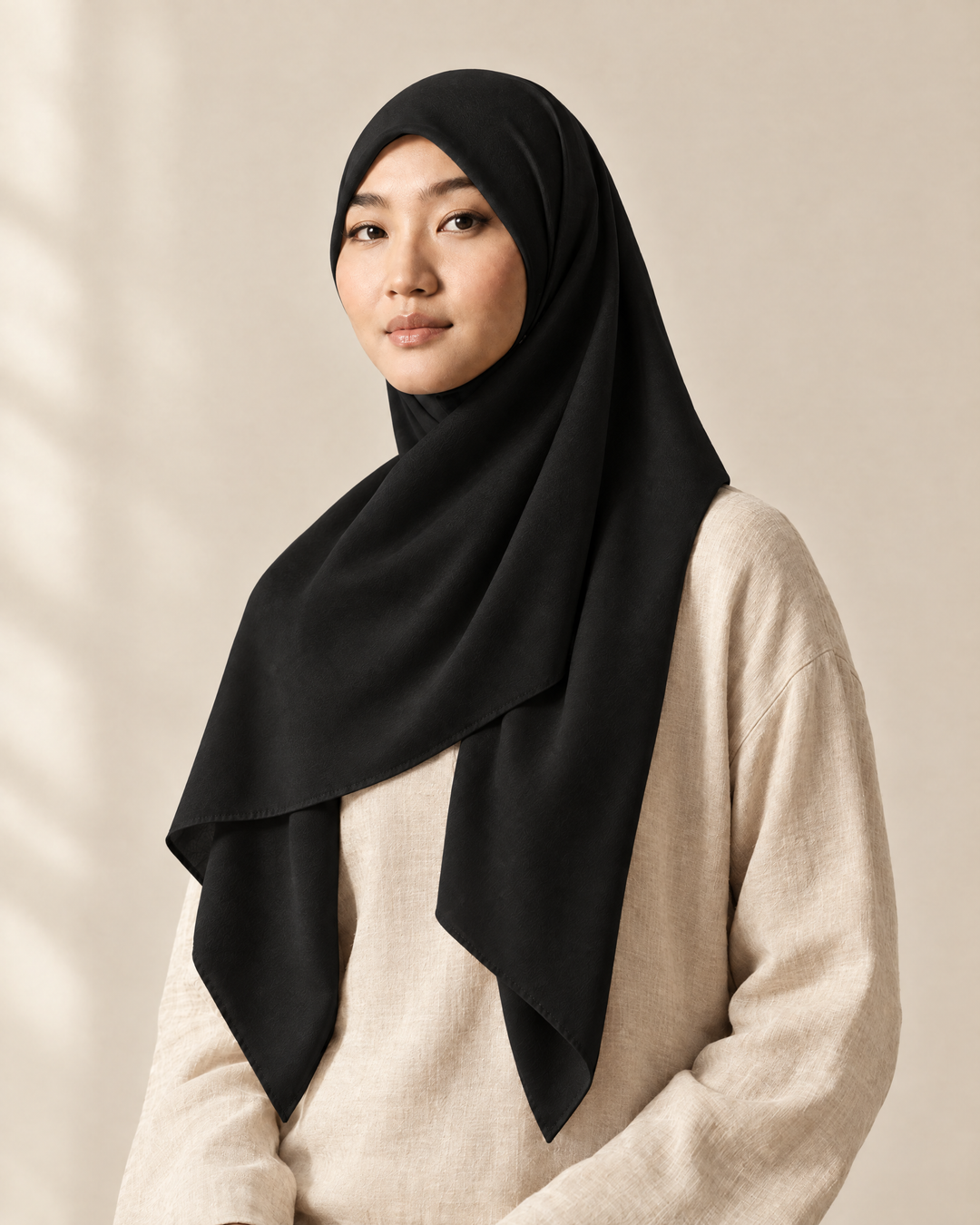 Hijab bawal segi empat Nuréa warna Hitam Pekat (Deep Black) dipakai model, tampak depan setengah badan