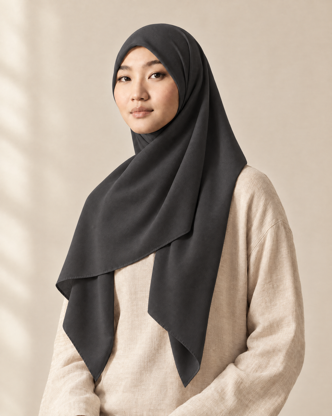 Hijab bawal segi empat Nuréa warna Abu Arang (Charcoal Grey) dipakai model, tampak depan setengah badan