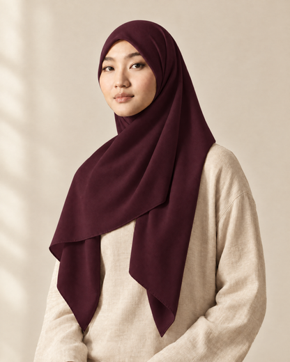 Hijab bawal segi empat Nuréa warna Anggur Plum (Plum Wine) dipakai model, tampak depan setengah badan