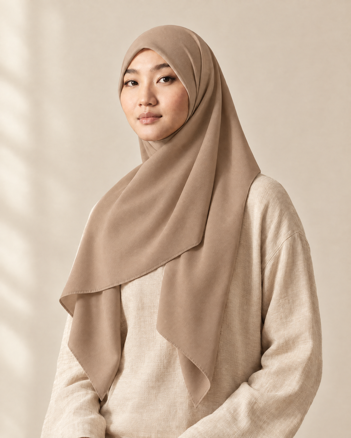 Hijab bawal segi empat Nuréa warna Krem (Beige) dipakai model, tampak depan setengah badan