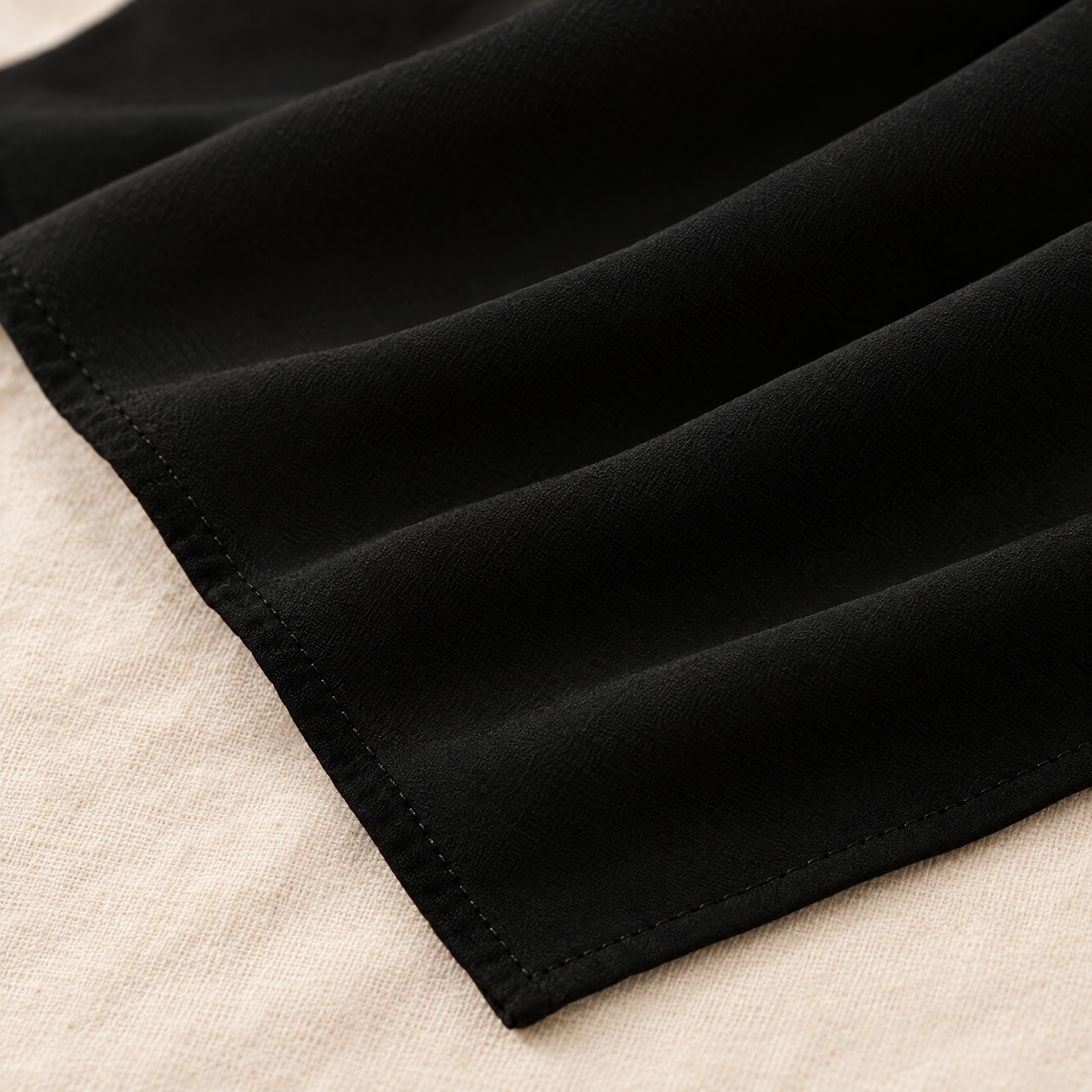 Detail kain polos dan jahitan tepi hijab bawal Nuréa warna Hitam Pekat (Deep Black)